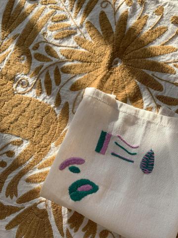 This photograph shows part of a Tenango embroidery project with a linen placed on top with example embroidery stitches.